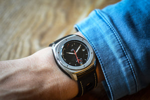 MHD Streamliner black dial watch with black leather rally strap on a mans wrist